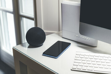 Smartphone, wifi speaker, router and computer on desk. Technology, domotics, home automation concept