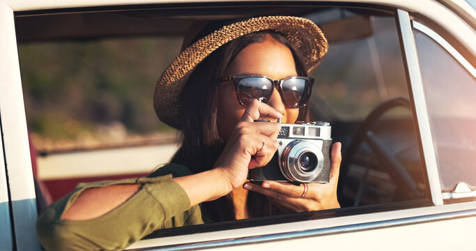 Woman, photographer and car with camera for road trip, sunset or memory on outdoor journey in nature. Female person with hat and sunglasses for capture, picture or sightseeing on adventure or tour