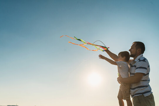 dad and little son 3 years old fly a kite in a field silhouette. Involved Parenting, International Father's Day