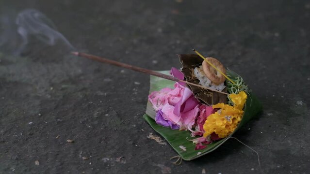 Canang Sari, a sacred offering in Balinese Hinduism. Placed on a leaf as a symbol of gratitude and respect towards the Gods. Slow motion footage.