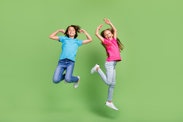 Full length photo of excited funky friends wear t-shirts jumping high enjoying sports isolated...