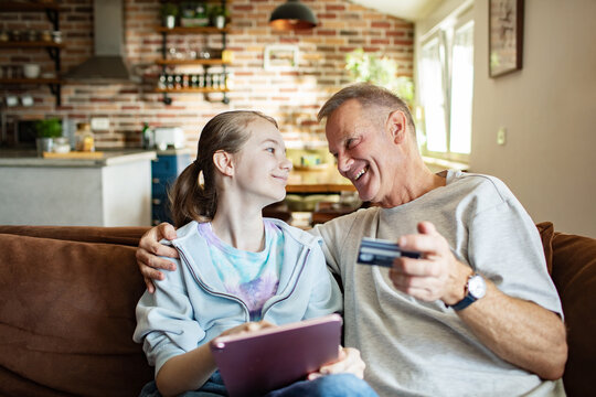 Father and daughter shopping online together at home