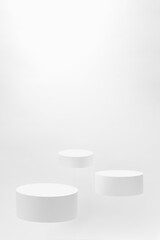 Abstract scene - three round white tilt podiums for cosmetic products mockup, fly on white background. For presentation skin care products, gifts, goods, advertising, showing, sale in minimal style.