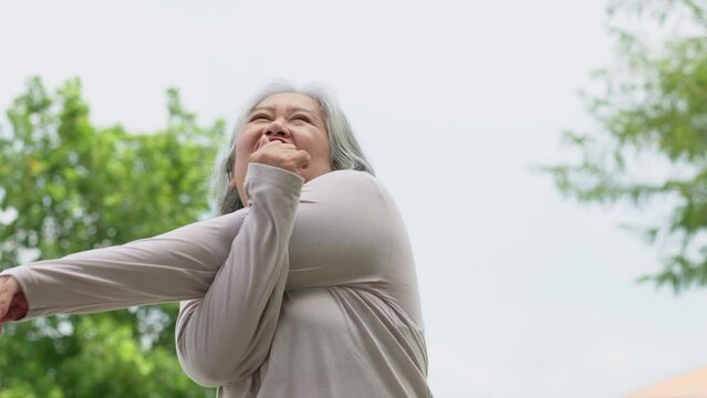 Senior woman jogging in outdoor stadium. Elderly female person is happy about cardio for health and wellness while walking or running in summer. Concept of healthcare and active lifestyle for healthy