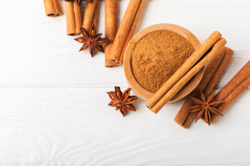 Cinnamon sticks and anise on a textured background. Cinnamon roll and star anise. Spicy spice for baking, desserts and drinks. Fragrant ground cinnamon.Place for text. copy space.