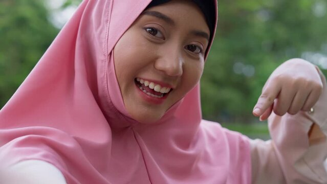 Closeup face of cheerful young woman covered with headscarf smiling outdoors. Casual Islamic girl in park. Freedom and relaxing outdoors. Happiness, smile, and face of Islamic female person with joy