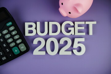 Budget 2025 alphabet letters with piggy bank and calculator top view on purple background