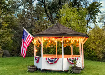 Gazebo in the country decorated with red, white, and blue bunting and an American flag