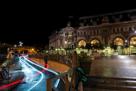 Low exposure photograph of bicycle park and the lights of a car leaving the Paris-Lyon station at night. Paris. France. August 11, 2023.