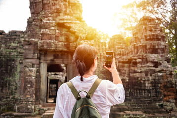 Female tourist taking photo of ancient Angkor temple in Cambodia - 787257837