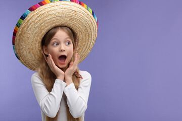 Emotional girl in Mexican sombrero hat on purple background. Space for text