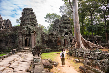 Female tourist walking to ancient Angkor temple in Cambodia
