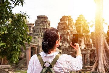 Female tourist taking photo of ancient Angkor temple in Cambodia - 787259064