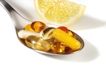 Pills on a spoon on white background