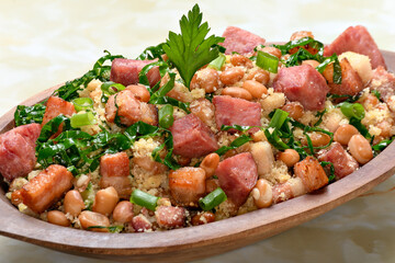 Tropeiro beans in a wooden container, typical food from Minas Gerais, Brazil, yellow marble background
