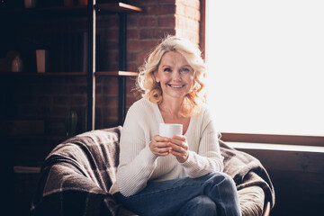 Photo portrait of lovely retired woman hold tea cup drink wear casual clothes cozy home interior...