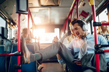 Businessman listening to music on headphones while commuting by bus