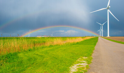 Dark sky and a rainbow over a rural landscape, Almere, Flevoland, The Netherlands, April 17, 2024