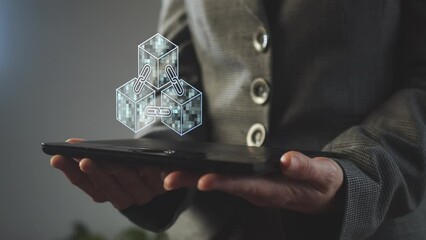 A hologram is an animated symbol of blockchain technology, which has the effect of flickering squares of various shades of turquoise above the tablet screen in the hands of a businesswoman. Cg - Powered by Adobe