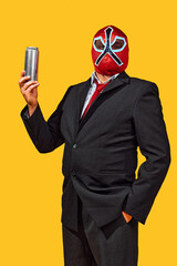 Confident man in wrestler attire with mask in official attire holds aluminum cane against yellow studio background. Concept of sport, active lifestyle and healthy eating, contemporary art.