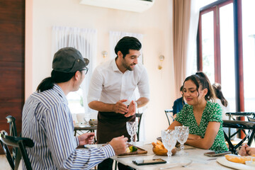 Happy Clients Enjoying Meals and Conversations at the Eatery: A Group of Friends Gathered Indoors, Smiling and Talking Over Lunch and Dinner, Creating Memorable Dining Experiences Together