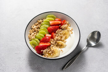 Granola with yogurt, fresh strawberries, kiwi, banana and nuts, seeds. Healthy breakfast. 