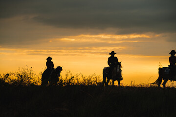 Obraz na płótnie Canvas cowboys and horses against the backdrop of breathtaking sunsets. Explore captivating silhouettes that embody the spirit of the Wild West and the beauty of nature