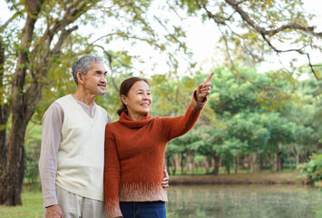portrait happy asian senior couple spend leisure time together in autumn park,concept of elderly people lifestyle,family,family relationship,holiday,travel