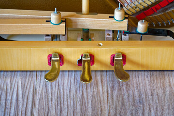 Close-up of gold colored pedals of open piano. Photo taken April 17th, 2024, Zurich, Switzerland.