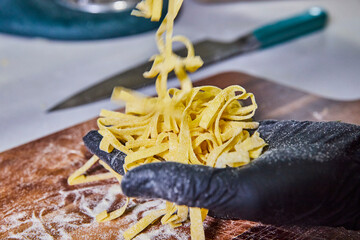 Fresh Tagliatelle Pasta in Motion, Culinary Craftsmanship - Eye-Level View