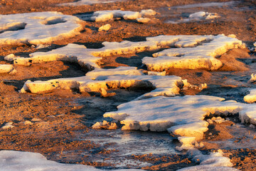 Spring thawing, streams washed away a layer of snow, spring flood. The snow shines in the rays of the rising sun