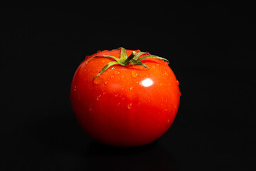 Ripe red tomato on a black background close-up. - 787281404