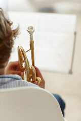 Sheets, music and child with trumpet for learning, jazz lesson and practice for talent show....