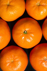 Fresh tangerines, fruit as a background on a black background, top view - 787284847