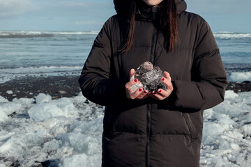 holding ice in hand on diamond beach in Iceland 