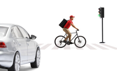 Delivery guy in a red t-shirt delivering food with a bicycle, crossing a road at a pedestrian zebra...