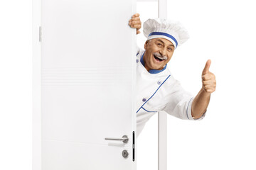 Mature male chef peeking from behind a door