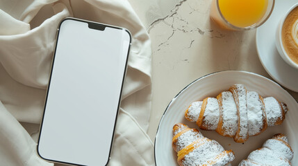 White Screen Smartphone Mockup on Marble Table with Morning Breakfast: Top View of Blank Screen Mobile Phone, Croissants, Coffee, and Orange Juice
