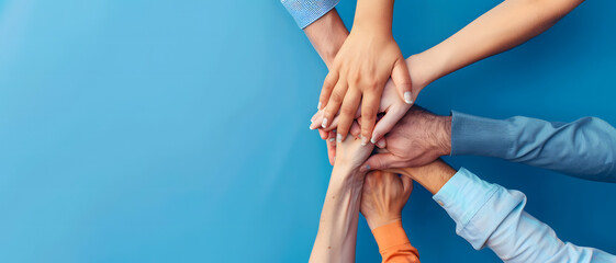 Capturing the essence of team spirit, a multi-ethnic group of individuals join hands in unity against a blue background