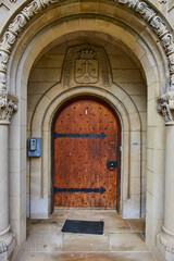 Fototapeta na wymiar Historical Wooden Door with Heraldic Crest and Modern Intercom