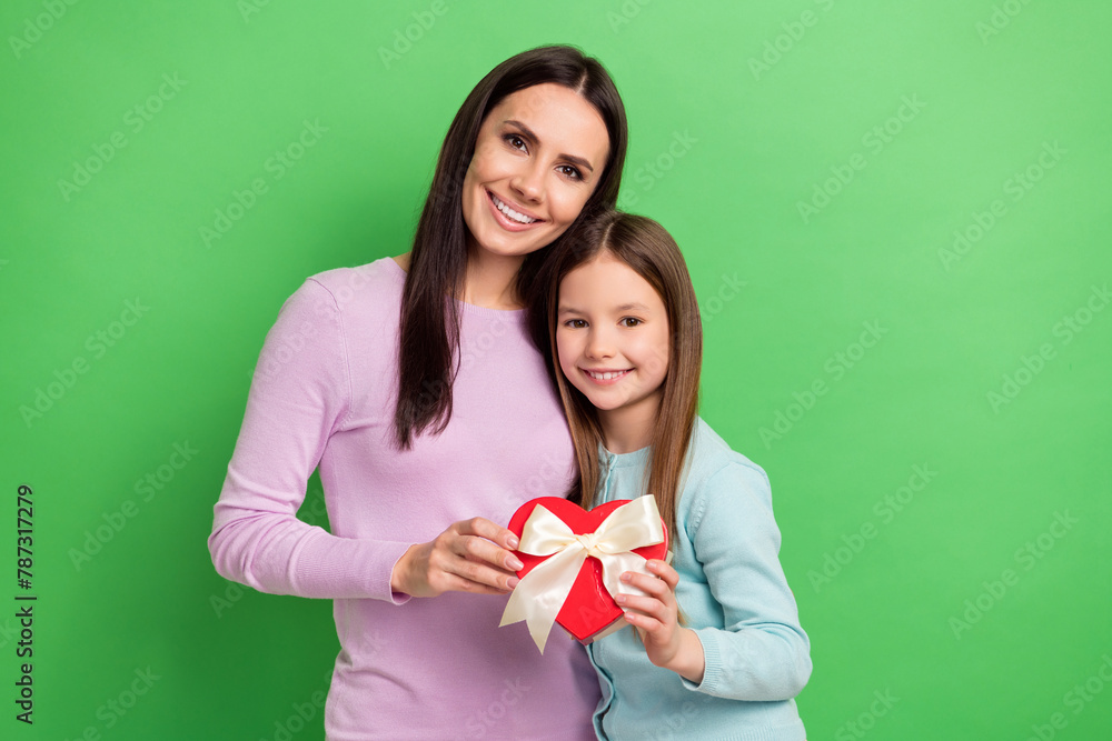 Sticker photo of two people mother daughter hold heart figure giftbox isolated on bright green color backgro