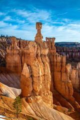 Tall hoodoo rock needle called „Thors hammer“ in Bryce Canyon National Park (Utah, USA) on a sunny winter morning with melting snow and bright blue sky. Famous beige-reddish sandstone formation.