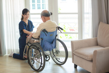 Fototapeta na wymiar asian woman doctor nursing home to helping take care to retirement patient who sitting on wheelchair, caregiver nurse support to medical health care insurance at home or hospital, elderly senior man