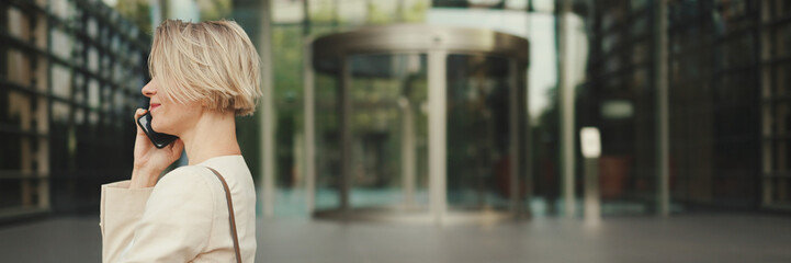 Close up, businesswoman talking on the cellphone on business center background, Panorama