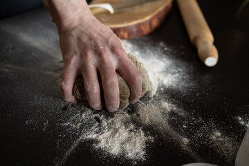 male hand knead dough from rye flour for baking bread or pizza
