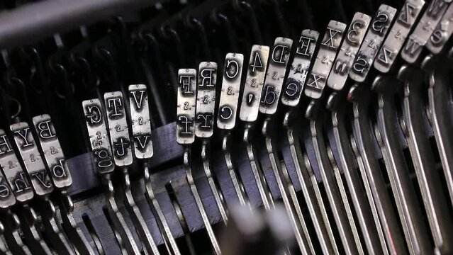 moving mechanics of long metallic levers with the characters in relief of a typewriter