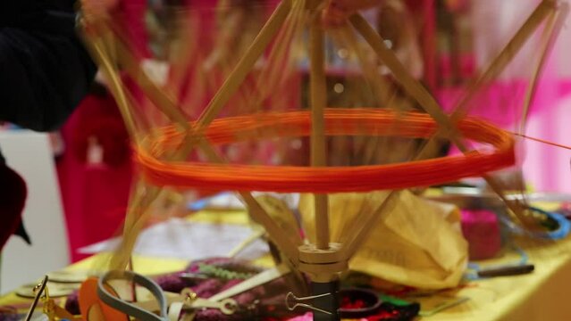 wooden spinning wheel that turns very quickly and thread for creating balls of yarn in knitting factory