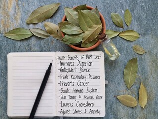 Health benefits of bay leaf. Medicinal uses of bay leaves. The list of bay laurel leaf health benefits handwritten in a notepad. Bay leaves are a spice used in cooking and have medicinal properties.