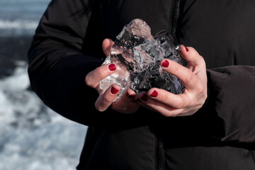holding ice in hand on diamond beach in Iceland 