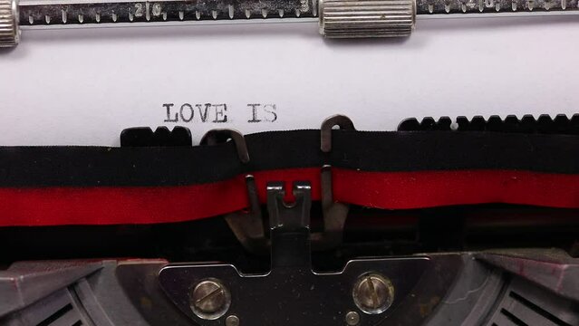 text LOVE IS LOVE written with a vintage typewriter with black ink